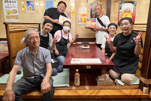最終日の閉店後に泉谷社長(左)と授業員、常連客で最後の記念写真