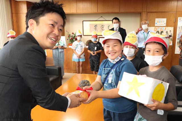 滝沢市長にナシを手渡す大島小児童