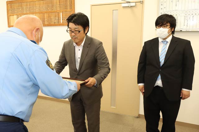 清水署長(左)から感謝状を受けるオーナーの菰田さん(中央)と店員の池田さん(右)