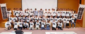 最後の定例会議で参加事業所が新たなキービジュアルをデザインしたTシャツを着て記念撮影