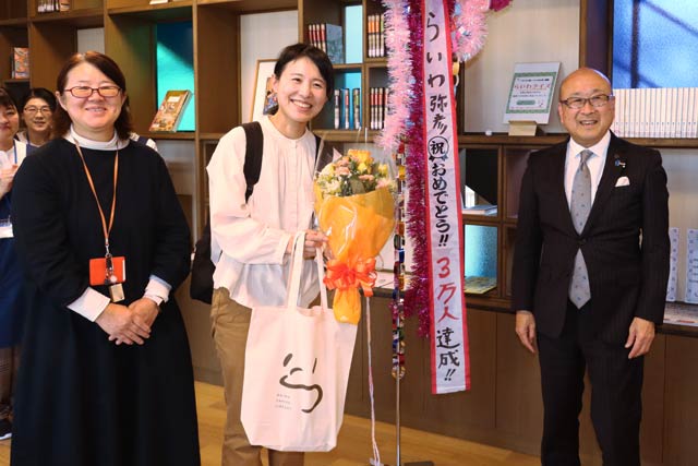 左から徳永館長、3万人目のヤマシタナツミさん、本間村長
