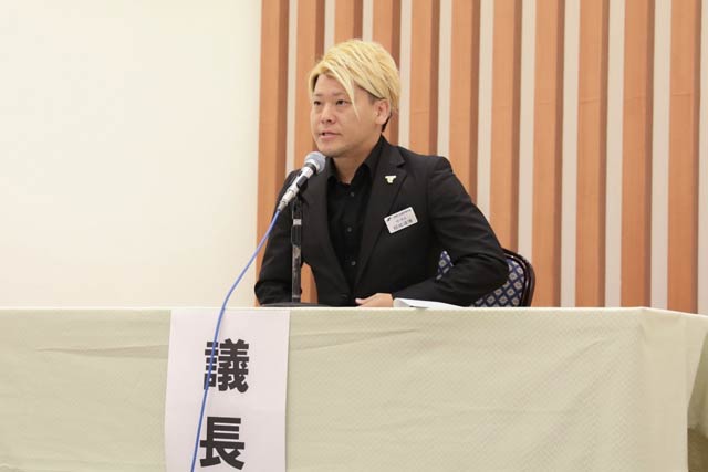 臨時総会で議長をつとめる結城会長