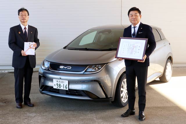 寄付したBYDのドルフィンの前で鈴木市長(左)と丸山代表取締役