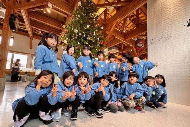 オーナメントの飾りが完成したクリスマスツリーの前で記念写真