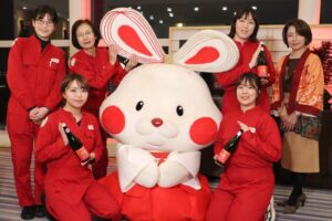 弥彦のマスコットキャラクター「ミコぴょん」を囲んで女性社員と弥彦酒造の岡本さん