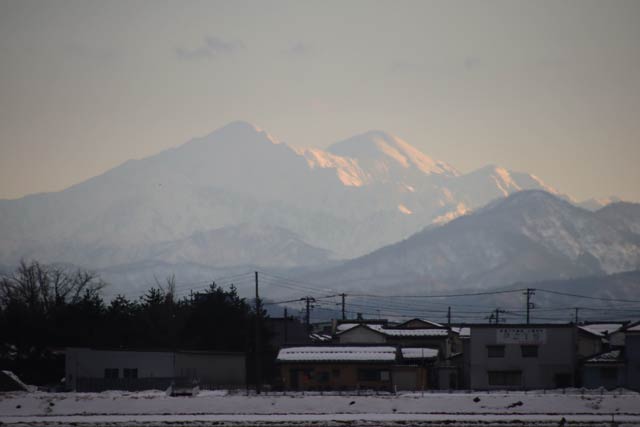 越後駒ヶ岳と思われるいちばん高い山など遠くの山が日差しに輝く