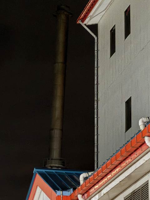 手前の建物の垂直な壁と比べると煙突がわずかに右に傾いているのがわかる