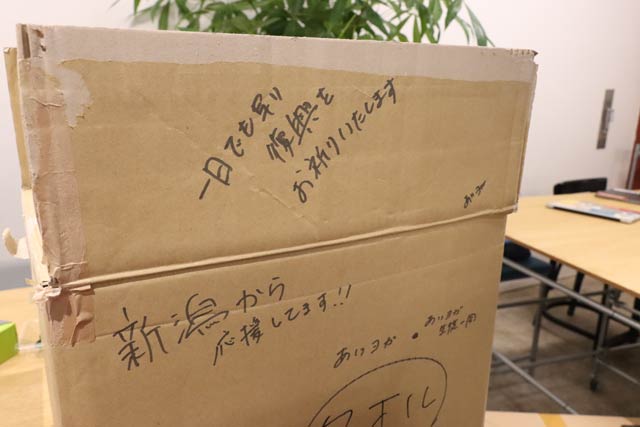 段ボール箱にマジックで書かれた被災者を励ます言葉’