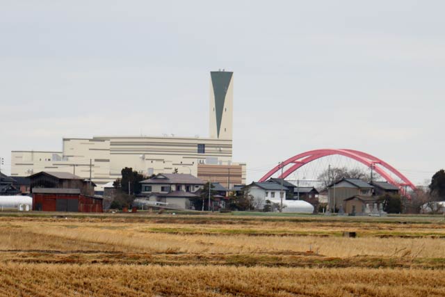 長岡市中之島クリーンセンターの向こうに信濃川の両岸の燕市と長岡市を結ぶ赤い本川橋が見える