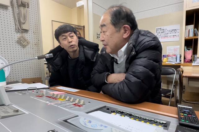 放送室で馬場駅長(左)と開発リーダーの小柳さん