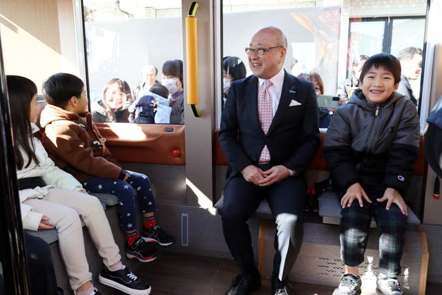 園児と乗車する本間村長
