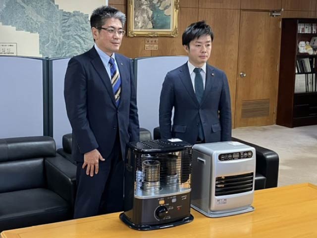 コロナガ支援物資として寄付する暖房機器と大桃社長(左)、滝沢市長