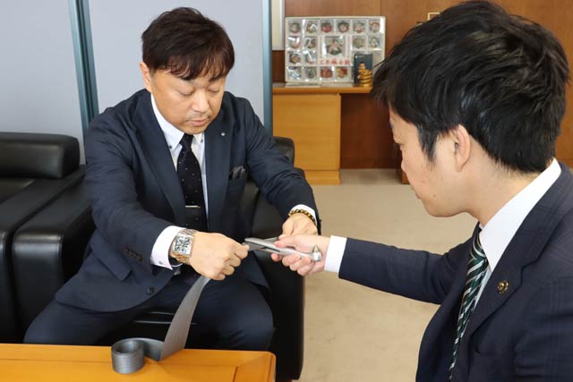 ミッドの小木寝佐波代表取締役(左)とミッドの「クライシス」の切れ味を試す滝沢市長