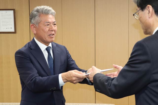 森井紙器工業から100万円の寄付を鈴木市長に手渡す森井社長(左)