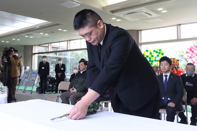 避難者代表の佐藤聖之さんが献花