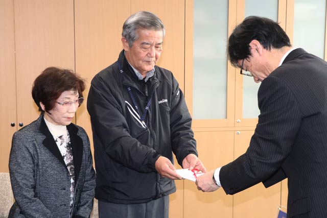 寄付を鈴木市長に手渡す