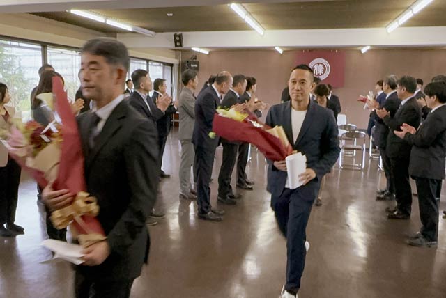 拍手に送られる退職者