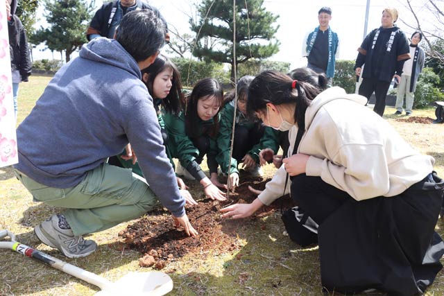 書道部員とFacebook Japanの味澤代表らがシダレザクラを植樹
