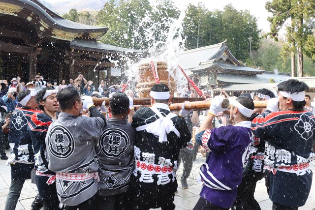 弥彦神社拝殿前で奉納した神湯をもむ