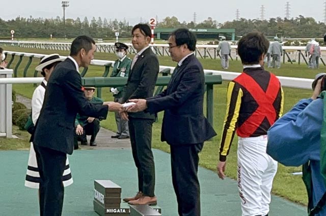 三条ステークス競走表彰式で梨本三条観光協会会長(左)がプレゼンターに