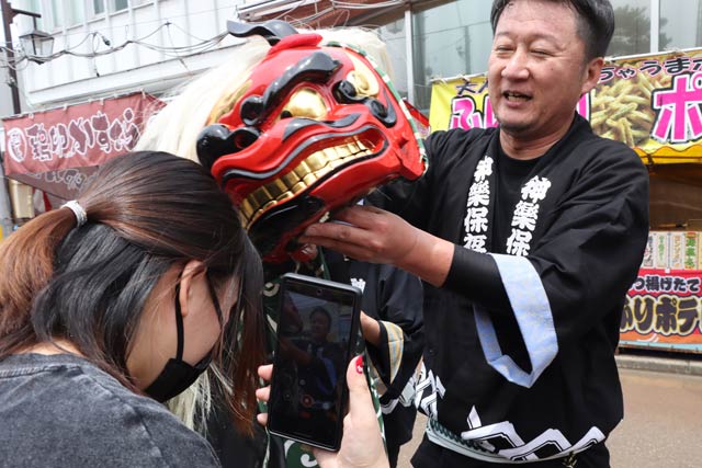 獅子頭に頭をかんでもらって無病息災を祈願