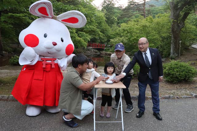 点灯式でいちばん右の本間村長の隣りが竹あかりを製作した武石さん