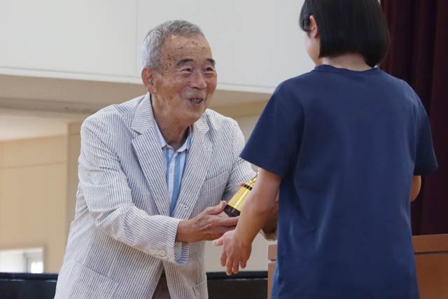 燕北中生徒に1970年の国際マラソン優勝のトロフィーを手渡す宇佐美さん