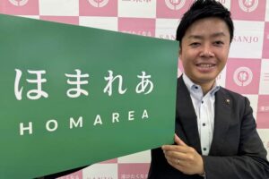 歴史民俗産業史料館別館の愛称に決まった「ほまれあ」のプレートを手に滝沢市長