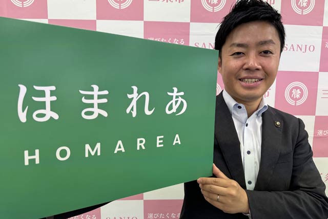 歴史民俗産業史料館別館の愛称に決まった「ほまれあ」のプレートを手に滝沢市長