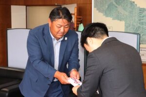 ゴルフコンペのチャリティーで参加者から寄せられた善意を滝沢市長に手渡す鹿峠会の若林会長