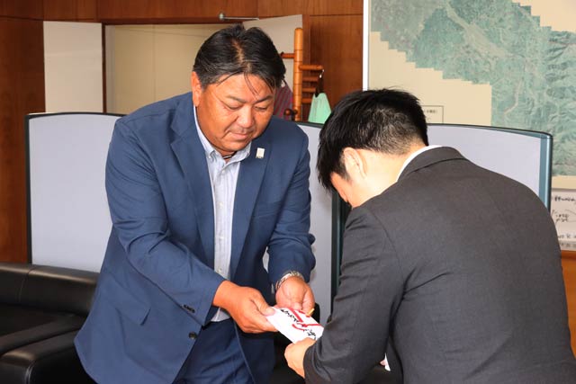 ゴルフコンペのチャリティーで参加者から寄せられた善意を滝沢市長に手渡す鹿峠会の若林会長