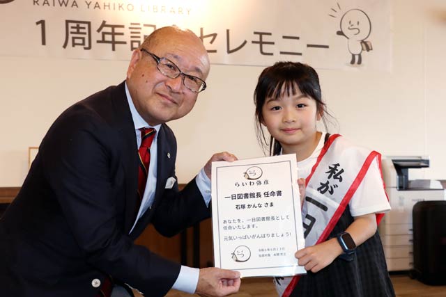 本間村長と1日図書館長に任命された弥彦小3年の石塚さん