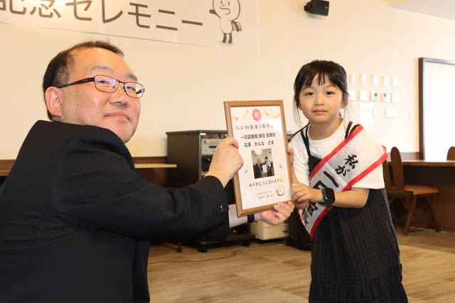石塚さんに1日図書館長の感謝状を手渡した三上副村長