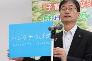 28日の定例記者会見で愛称に決まった「ハレラテつばめ」とあるパネルを掲げる鈴木市長