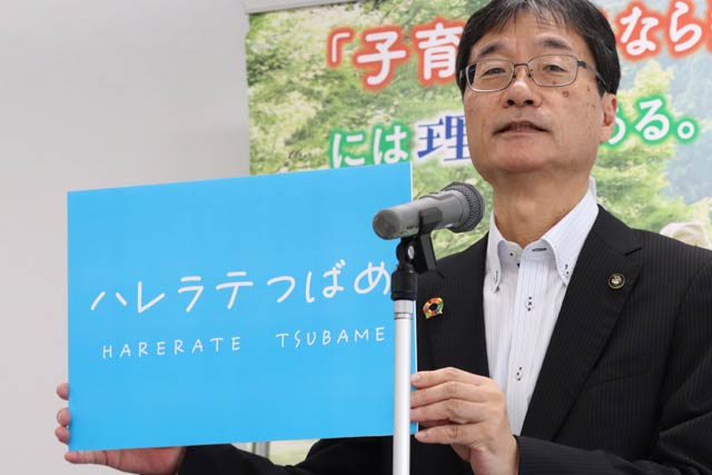 28日の定例記者会見で愛称に決まった「ハレラテつばめ」とあるパネルを掲げる鈴木市長
