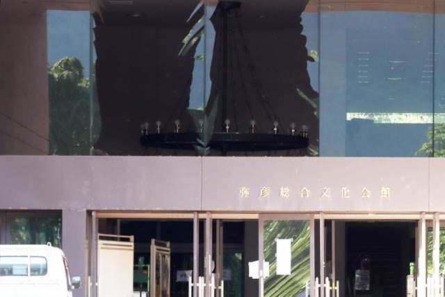 正面玄関上の2枚の大きなはめ殺しの窓ガラスが割れた弥彦総合文化会館