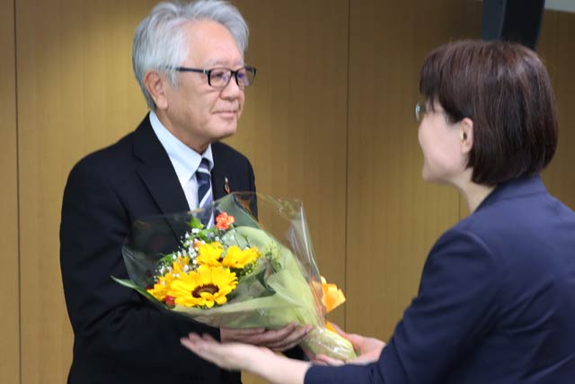 職員から花束を受け取る