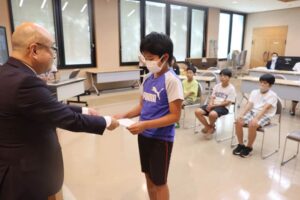 交流派遣団員に任命書を本間村長から交付