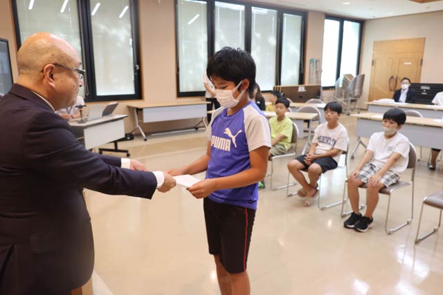 交流派遣団員に任命書を本間村長から交付
