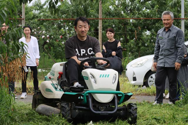 乗用草刈機を運転する捧さん