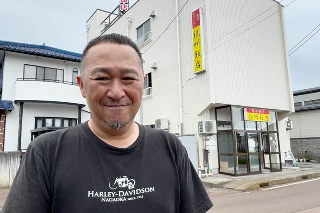 店舗の前で徐社長