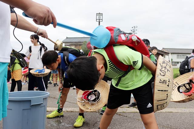 最初の休憩ポイントの旧荒沢小学校で首から冷水をかけて体の熱を冷ます