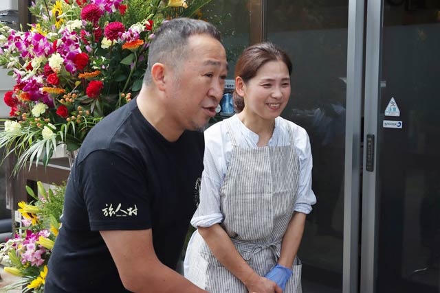 3カ月ぶりの開店前に開店を待つ人にあいさつする徐社長夫婦