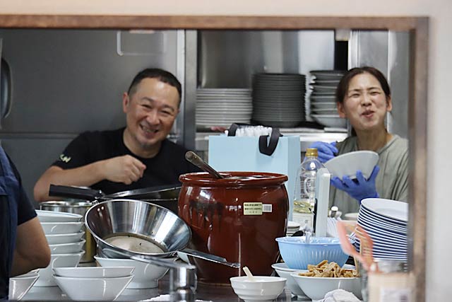 開店前に厨房でまかないを食べる徐社長夫婦