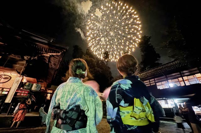 拝殿の前で浴衣で花火見物