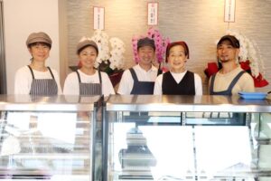 新しい店舗で中央が原田社長