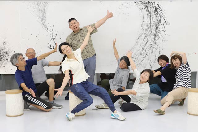 フォトスポットにもなる泉田さんの大作「風が運ぶもの 2022」の前で泉田さんと筆人たち