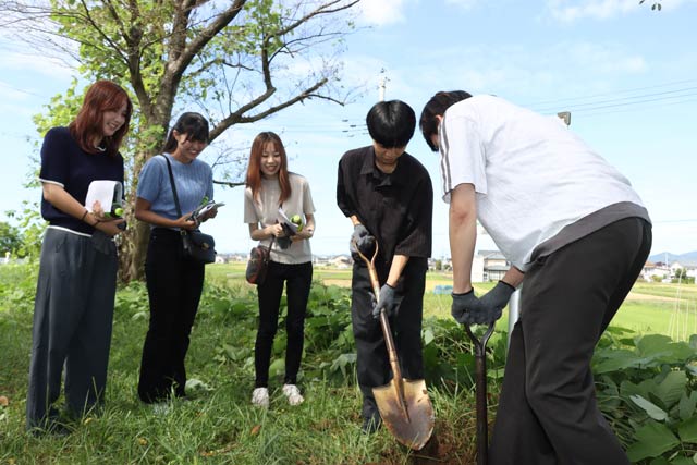 看板の下の土をシャベルで掘り起こす