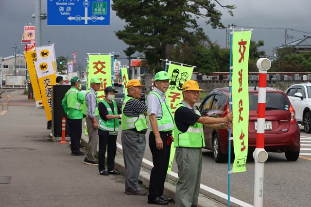 国道116号で「交通安全」ののぼり旗を掲げてドライバーに交通安全を呼びかけ