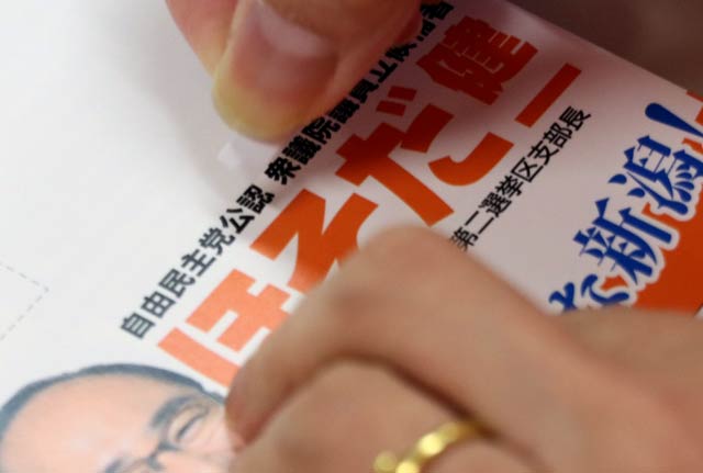 はがきの「公認」の文字にシールを張る作業